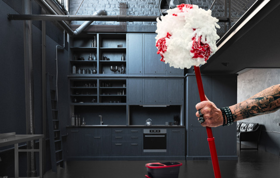 en tatuerad arm håller i en städmopp i ett mörkt rum